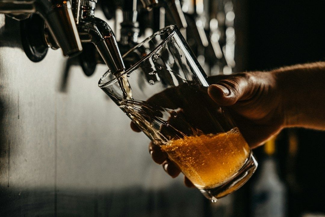 Öl hälls från en tappkran i ett lutat glas med bubblande skum